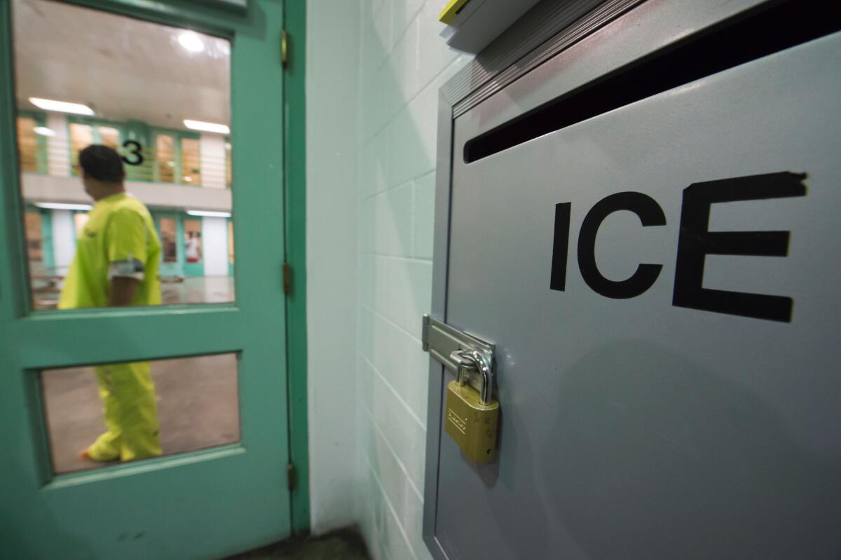 An immigration detainee stands near a U.S. Immigration and Customs Enforcement (ICE) grievance box.