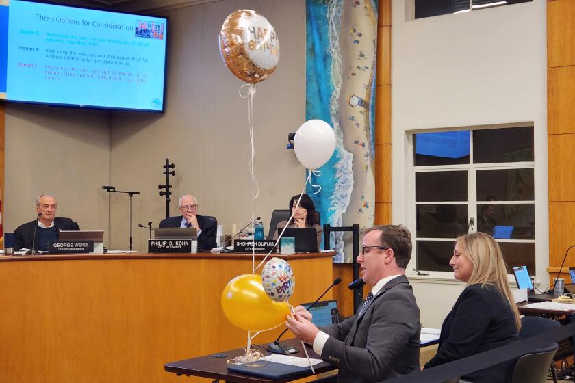 Jeremy Frimond, left, assistant to the city manager, demonstrates different types of balloons to the Laguna Beach City Council on Tuesday, Jan. 24, 2023.