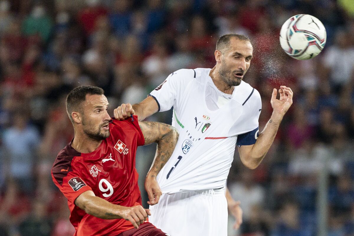 Switzerland's Haris Seferovic, left, fights for a header against Italy's Giorgio Chiellini during the World Cup 2022 group C qualifying soccer match between Switzerland and Italy at the St. Jakob-Park stadium in Basel, Switzerland, on Sunday, Sept. 5, 2021. (Georgios Kefalas/Keystone via AP)