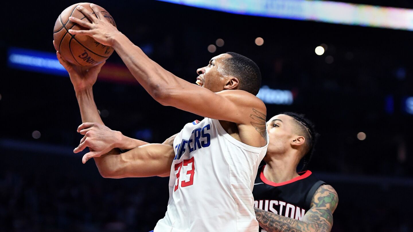 Clippers' Wesley Johnson is fouled by Houston Rockets' Gerald Green while driving to the basket in the first quarter.
