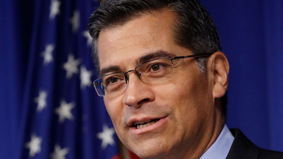 California Attorney General Xavier Becerra answers a question during a news conference.