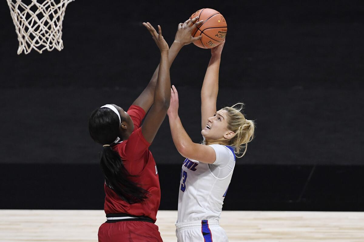 Louisville's Elizabeth Dixon, left, stops a shot-attempt by DePaul's Dee Bekelja in the first half of an NCAA college basketball game, Friday, Dec. 4, 2020, in Uncasville, Conn. (AP Photo/Jessica Hill)