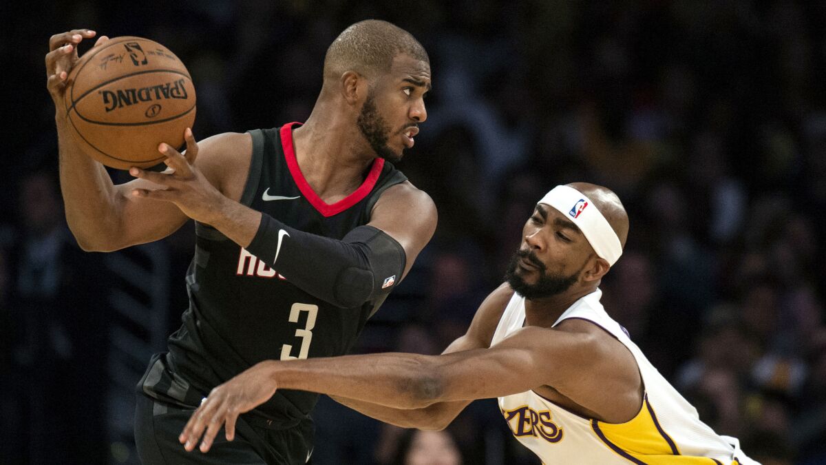 Rockets point guard Chris Paul protects keeps the ball away from Lakers forward Corey Brewer during a Dec. 3 game.