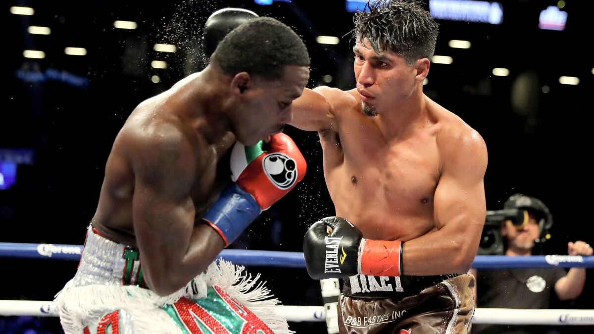 Mikey Garcia, left, and Adrien Broner exchange punches during their bout on Saturday.