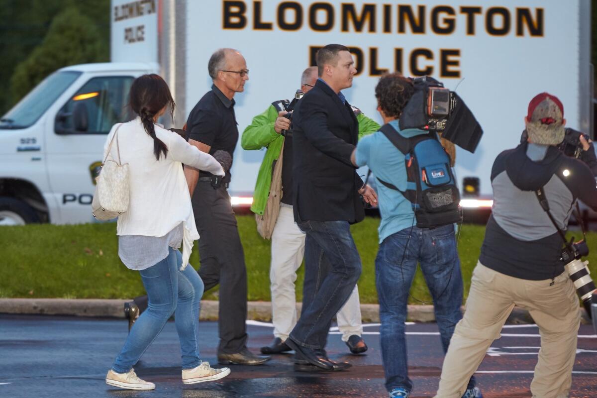 Dentist and trophy hunter Dr. Walter Palmer, left in black short sleeves, walks into his clinic with private security and among members of the media in Bloomington, Minn.