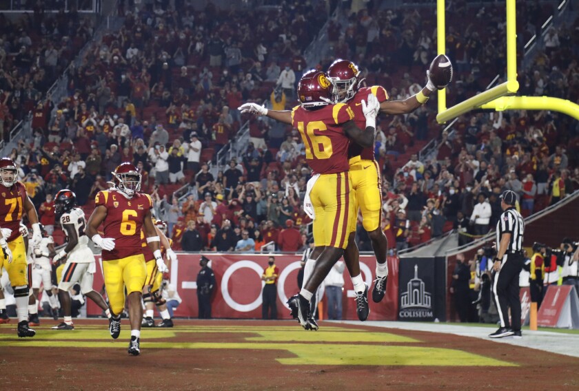 USC receivers Gary Bryant Jr. and Tahj Washington leap and bump chests to celebrate after a touchdown.