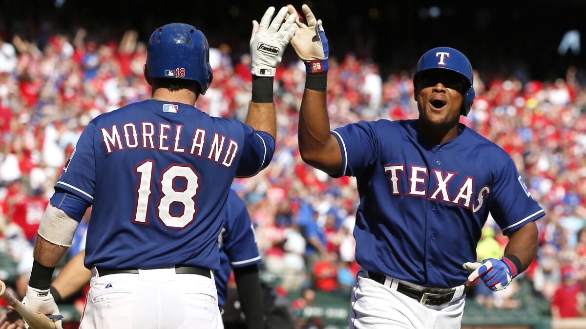 Rangers third baseman Adrian Beltre is congratulated by teammate Mitch Moreland after hitting a two-run home run against the Angels in the fifth inning Sunday afternoon.