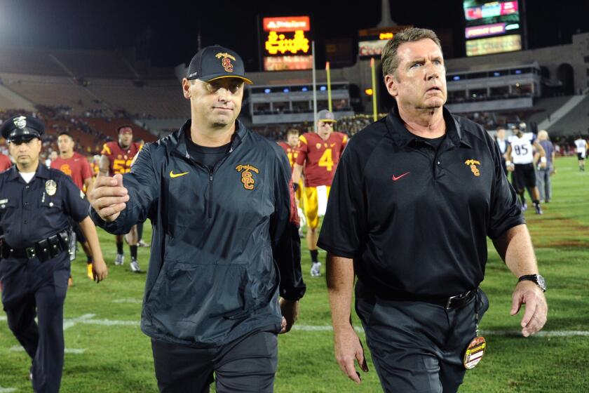 USC Coach Steve Sarkisian, left, walks off the field after losing to Washington, 17-12, at the Coliseum on Oct. 8.