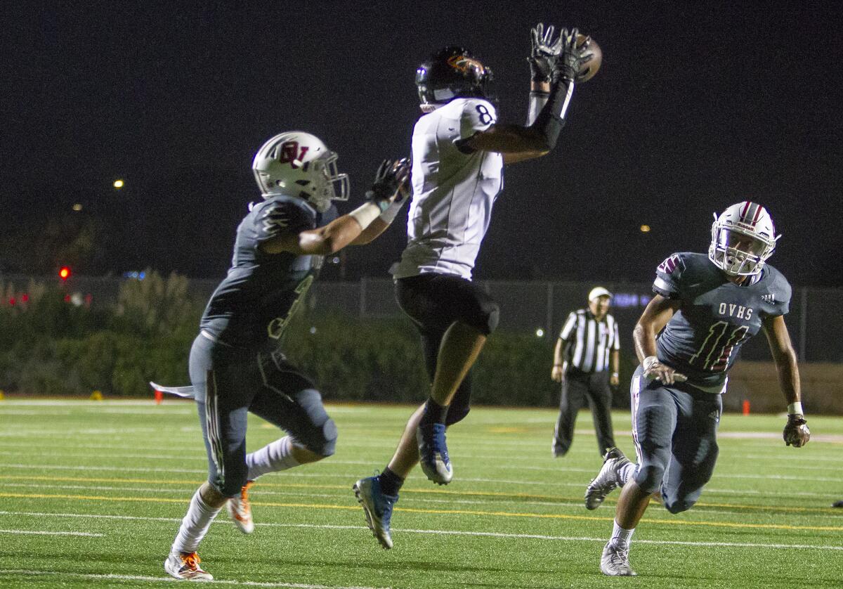 Los Amigos’ Juan Contreras goes up to catch a 10-yard touchdown against Ocean View’s Anthony Ramirez in a nonleague game on Friday in Huntington Beach.