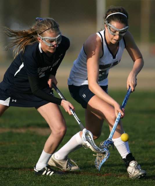 Newport Harbor's Chelsie Delameter, left, and Corona del Mar's Kylie Mulvaney battle for the ball during the Battle of the Bay lacrosse match at Newport Harbor High School on Friday.