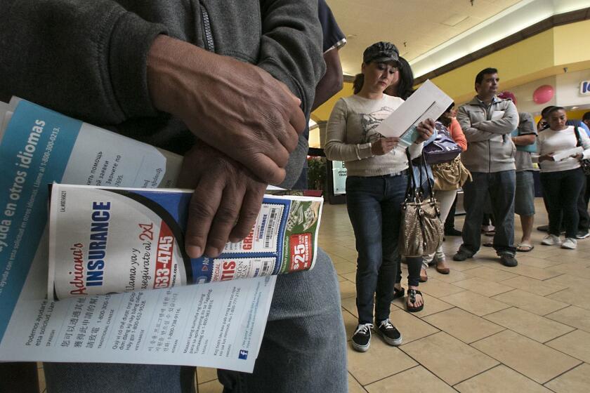 PANORAMA CITY, CA MARCH 28, 2014 -- Lourdos Leanos, of North Hollywood in baseball cap, and many other stand in line at Panorama Mall to sign-up for Covered California enrollment event on Friday morning ahead of Monday's deadline. (Irfan Khan / Los Angeles Times)