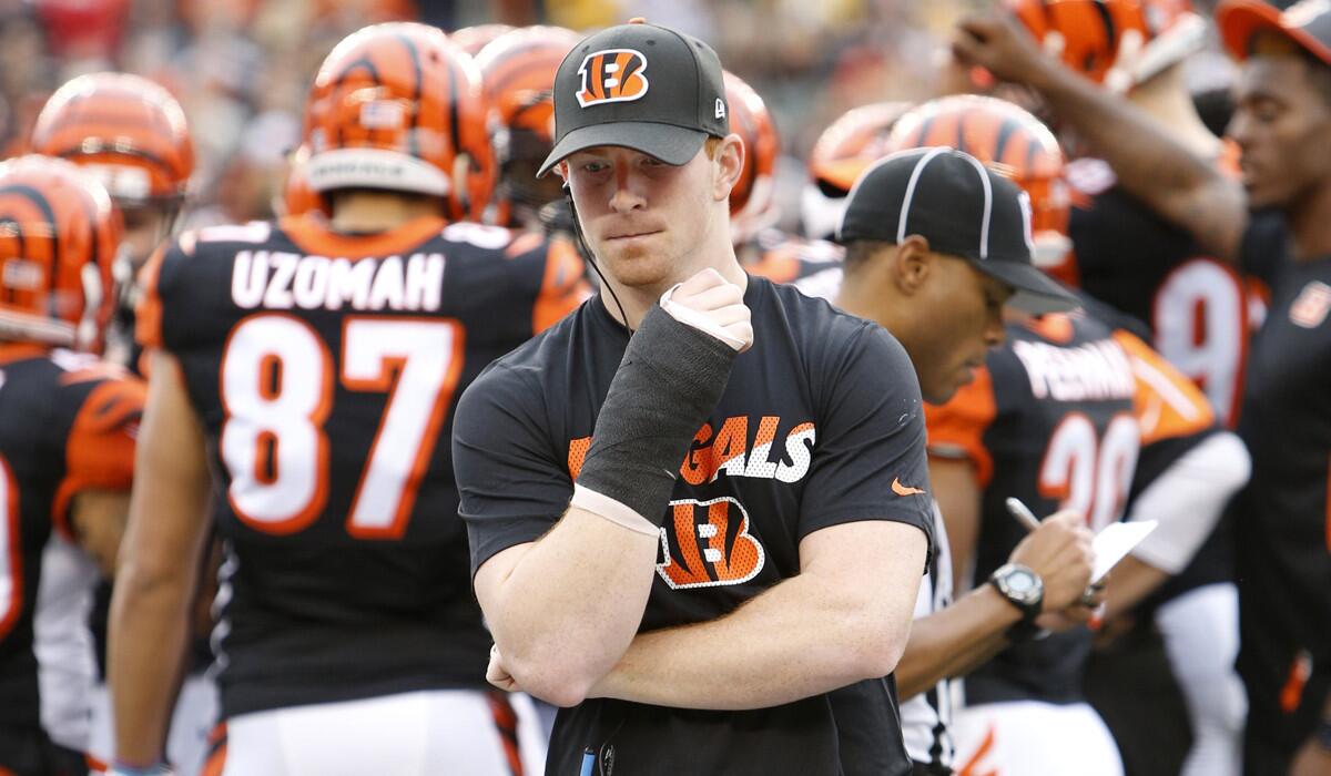 Cincinnati Bengals quarterback Andy Dalton walks the sidelines in a cast on his throwing hand on Sunday.