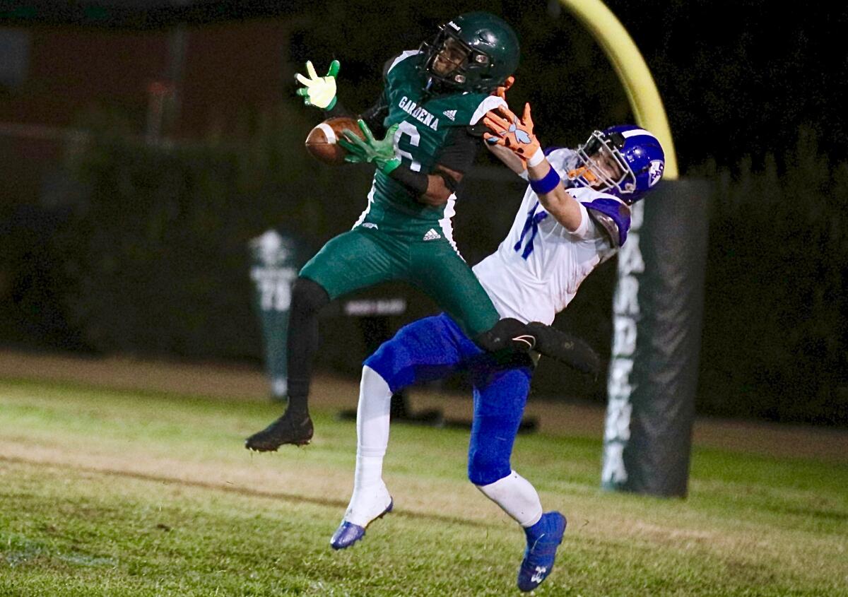 Gardena defensive back D'maj Longley, left, tries to pick off a pass against Palisades.