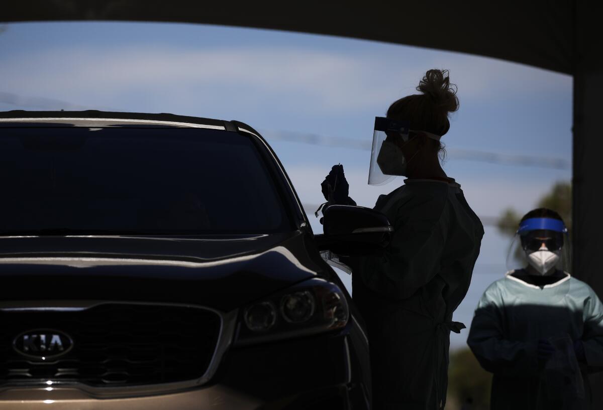 Healthcare workers test patients in their cars in Las Vegas.