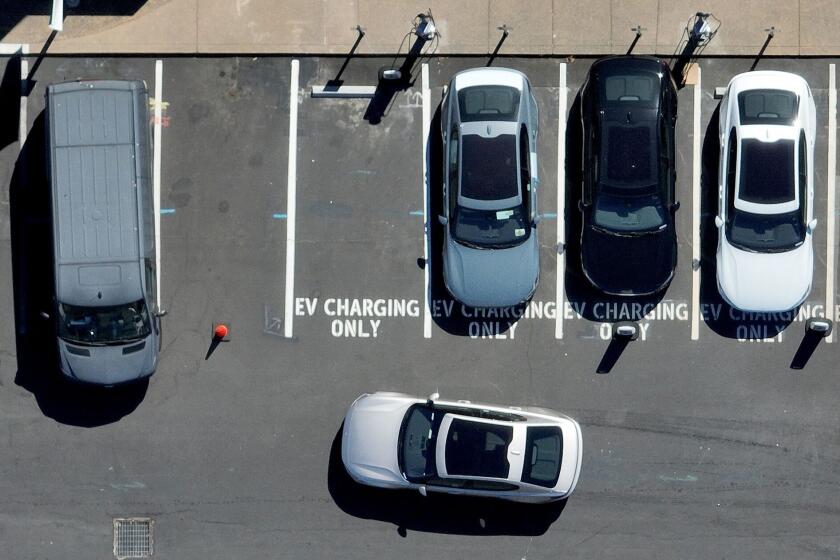 An electric car prepares to park at an EV charging station in Corte Madera, California.