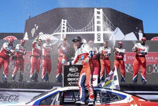 Kyle Larson, center, is doused with champagne by his team after winning a NASCAR Cup Series.