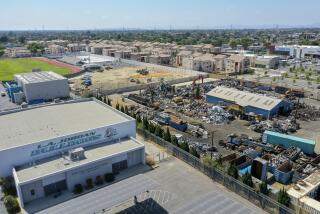 WATTS, CA - JUNE 16: An aerial view of Atlas Iron & Metal Co., which is a metal recycler that has piles of metal scrap and debris adjacent to newly-built Jordon Downs public housing, shown at top of photo, and Jordan High School Tuesday, June 16, 2020 in Watts, CA. (Allen J. Schaben / Los Angeles Times)