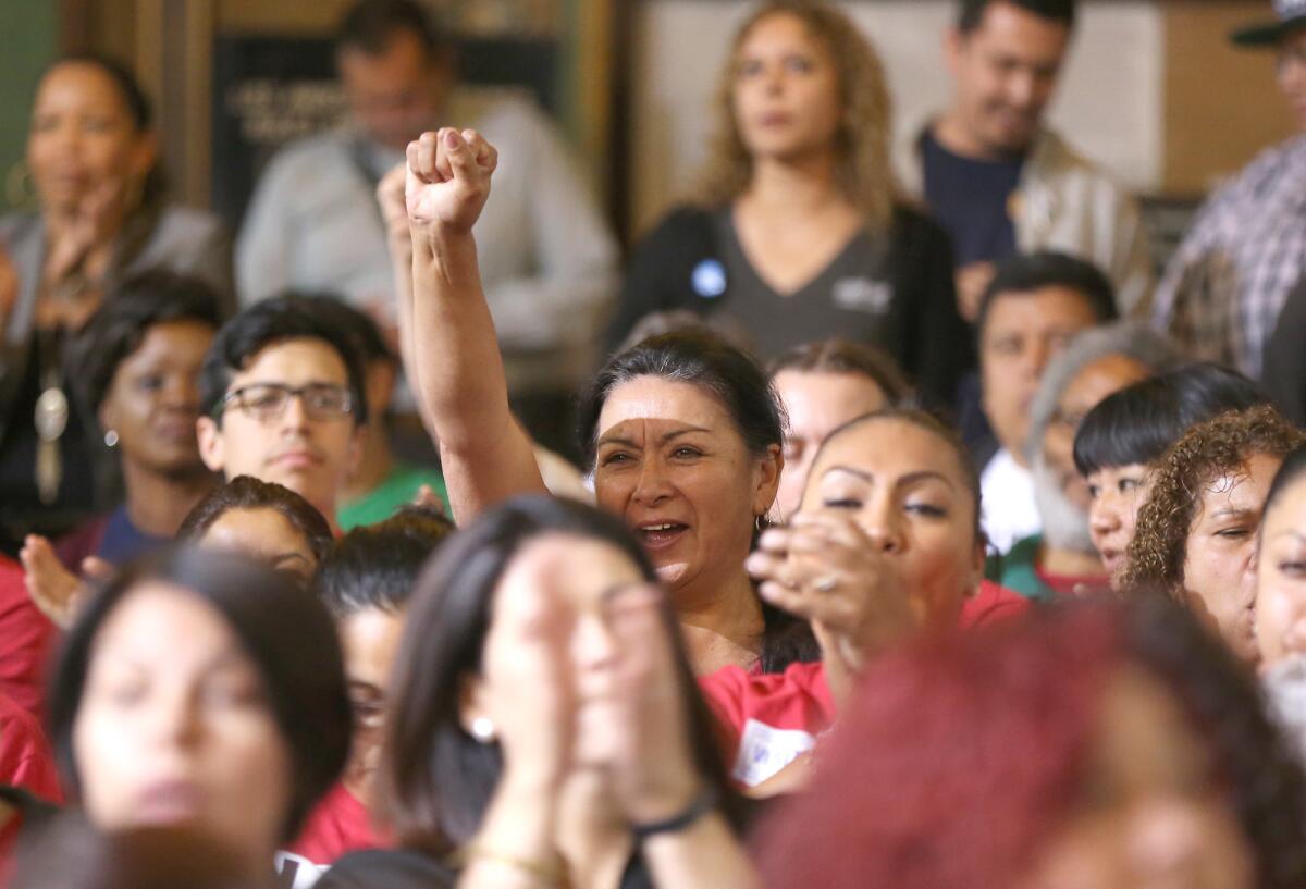 Trabajadores reaccionan en momentos en que el Concejo Municipal de Los Ángeles vota a favor de incrementar gradualmente el salario mínimo de la ciudad hasta llegar a 15 dólares por hora en 2020, el martes 19 de mayo de 2015, en Los Ángeles.