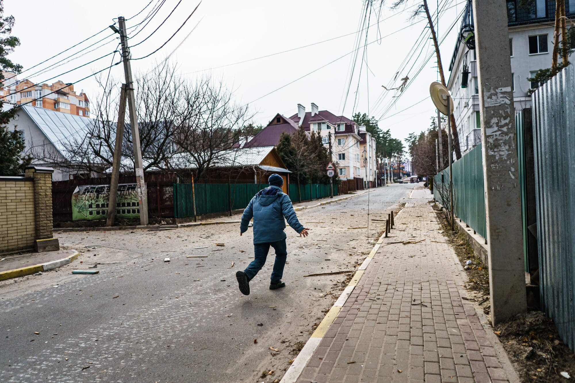 Ukrainian volunteers seek to save the living outside Kyiv - Los Angeles Times 10 A person running through a residential street