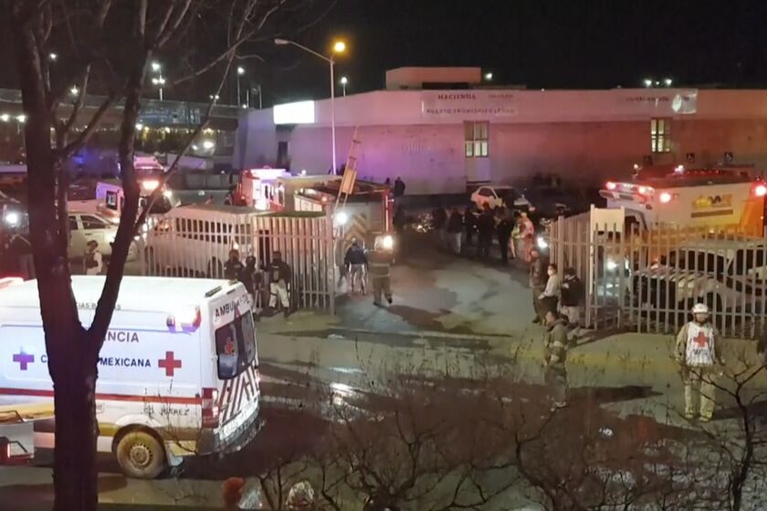 Esta imagen extraída de un video muestra ambulancias y equipos de emergencias ante un centro migratorio en Ciudad Juárez, México, el martes 28 de marzo de 2023. Un incendio en un centro de detención de migrantes en la ciudad fronteriza de Ciudad Juárez, en el norte de México, dejó 39 muertos y 29 heridos, según dijo el martes un funcionario. (AP Foto)