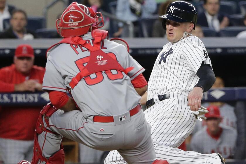 New York Yankees' Johnny Barbato slides past Angels catcher Carlos Perez to score on a Brett Gardner single during the fourth inning on Wednesday.