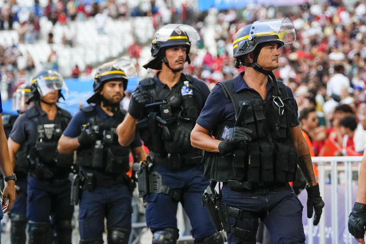 Police are seen near the pitch during a men's semifinal soccer match between Morocco and Spain at the 2024 Summer Olympics.