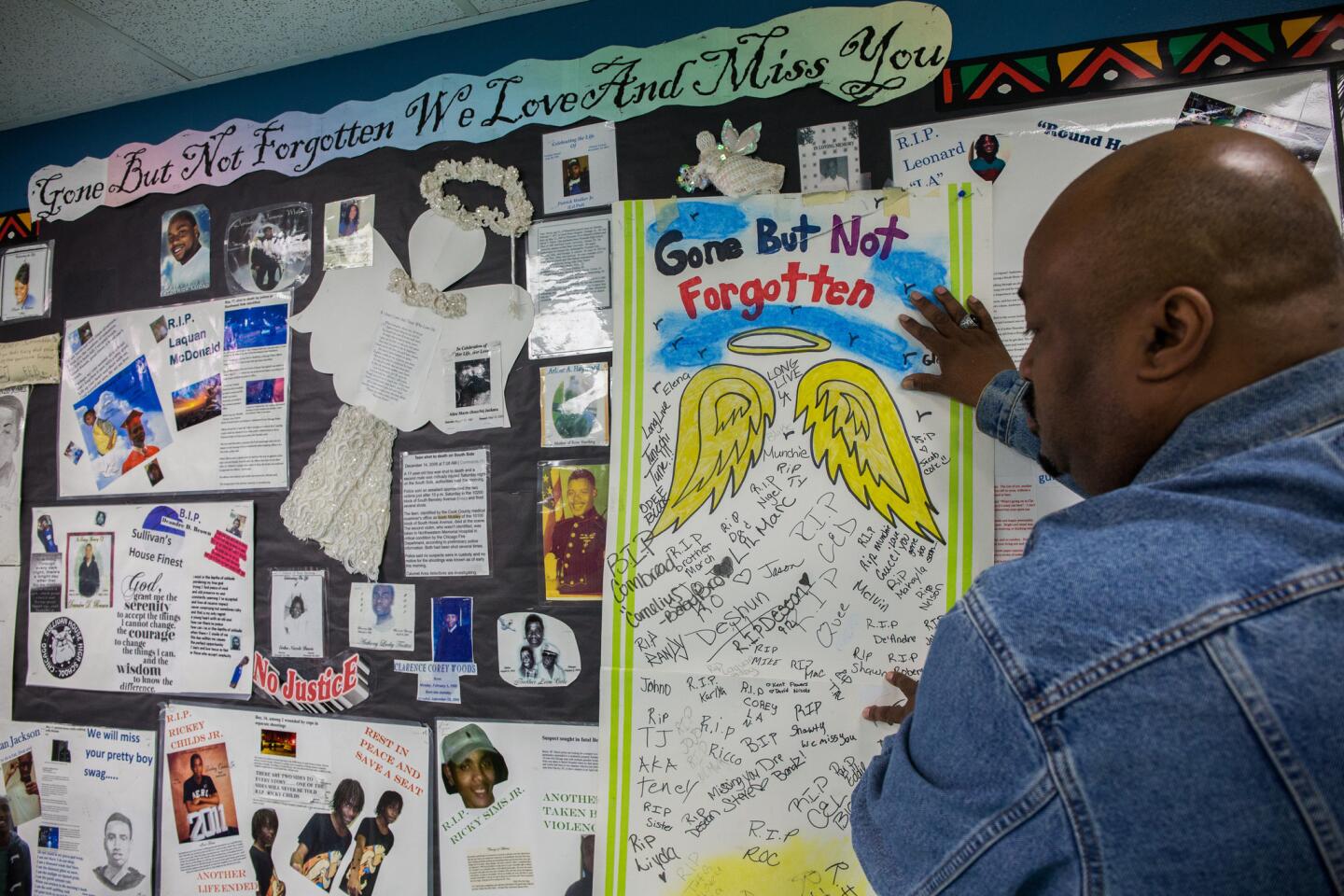 School counselor Darnell Payne adds another panel to a memorial for victims of violence, including 17-year-old Laquan McDonald, at Sullivan House Alternative High School in Chicago on April 17, 2015.