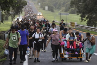 A long line of people along a rural road.