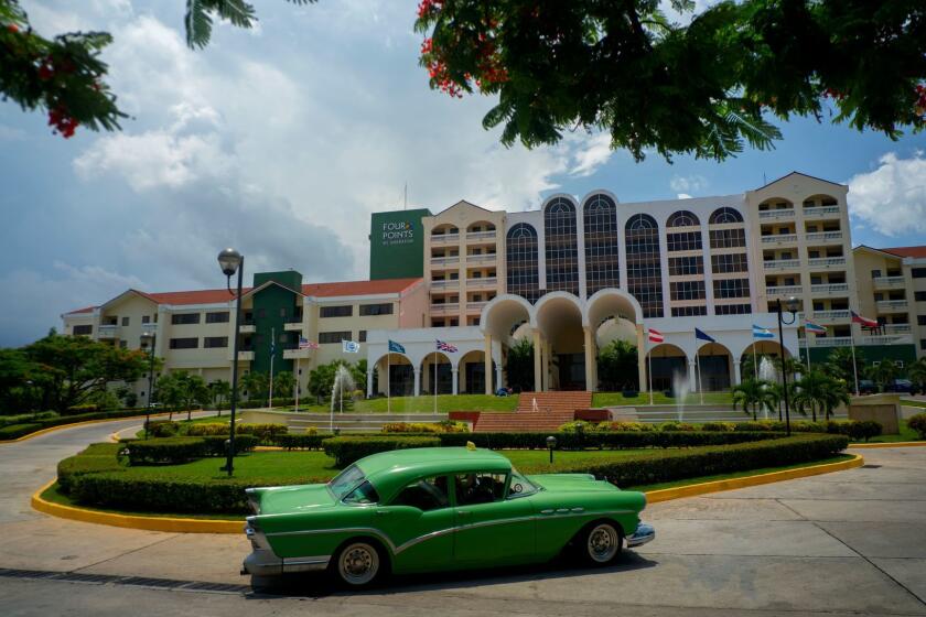 FILE - In this June 28, 2016 file photo, a vintage car passes in front of the Four Points by Sheraton hotel in Havana, Cuba. The Trump administration is close to announcing a new policy that would prohibit business with the Cuban military while maintaining the full diplomatic relations restored by Obama, according to a Trump administration official and a person involved in the ongoing policy review.(AP Photo/Ramon Espinosa,File)