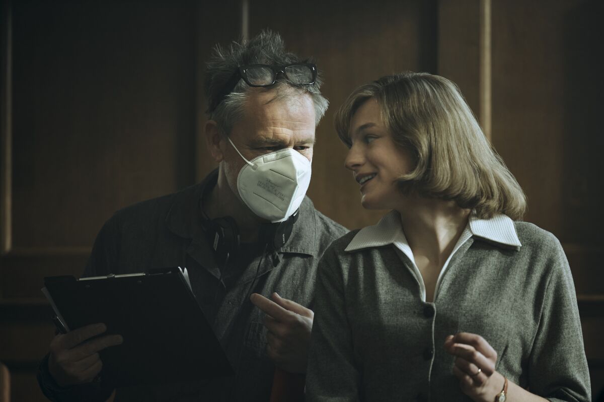 Michael Grandage, in a mask, directs Emma Corrin on the set of "My Policeman."
