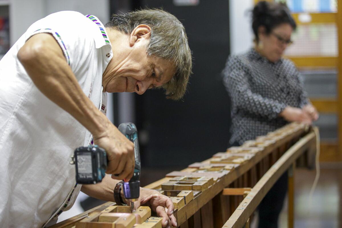 Rosauro Esteban, a Guatemalan musician, restores an old marimba, part of an effort to maintain a cultural connection.