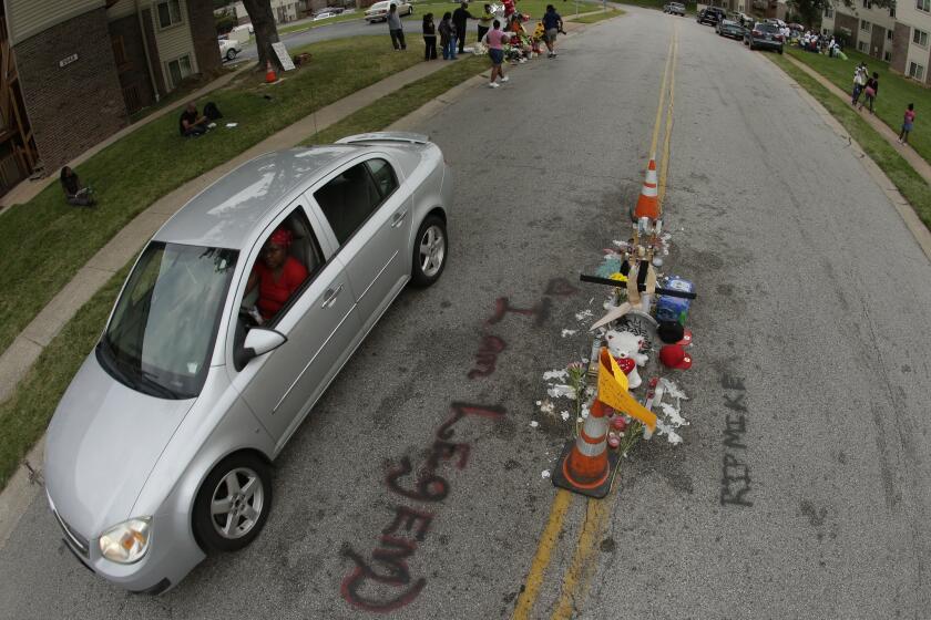 A memorial in the middle of the street where Michael Brown was shot and killed by a police officer in Ferguson, Mo.
