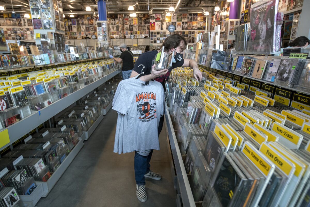 A person looks through CDs for sale at Amoeba Music.