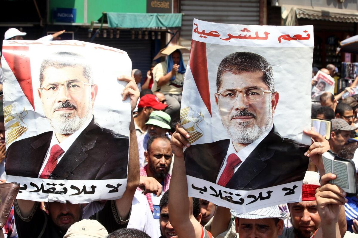 Supporters of Egypt's Muslim Brotherhood hold posters of ousted President Mohamed Morsi at a rally in Cairo.