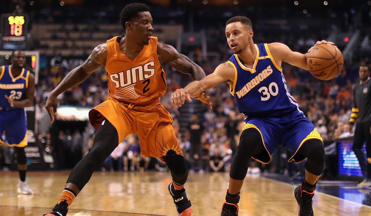 Golden State's Stephen Curry, left, handles the ball under pressure from Phoenix's Eric Bledsoe during the first half Sunday.