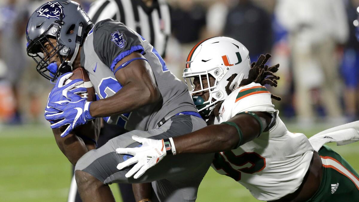 Duke's Brittain Brown is tackled by Miami's Mike Smith during the first half of an NCAA college football game.