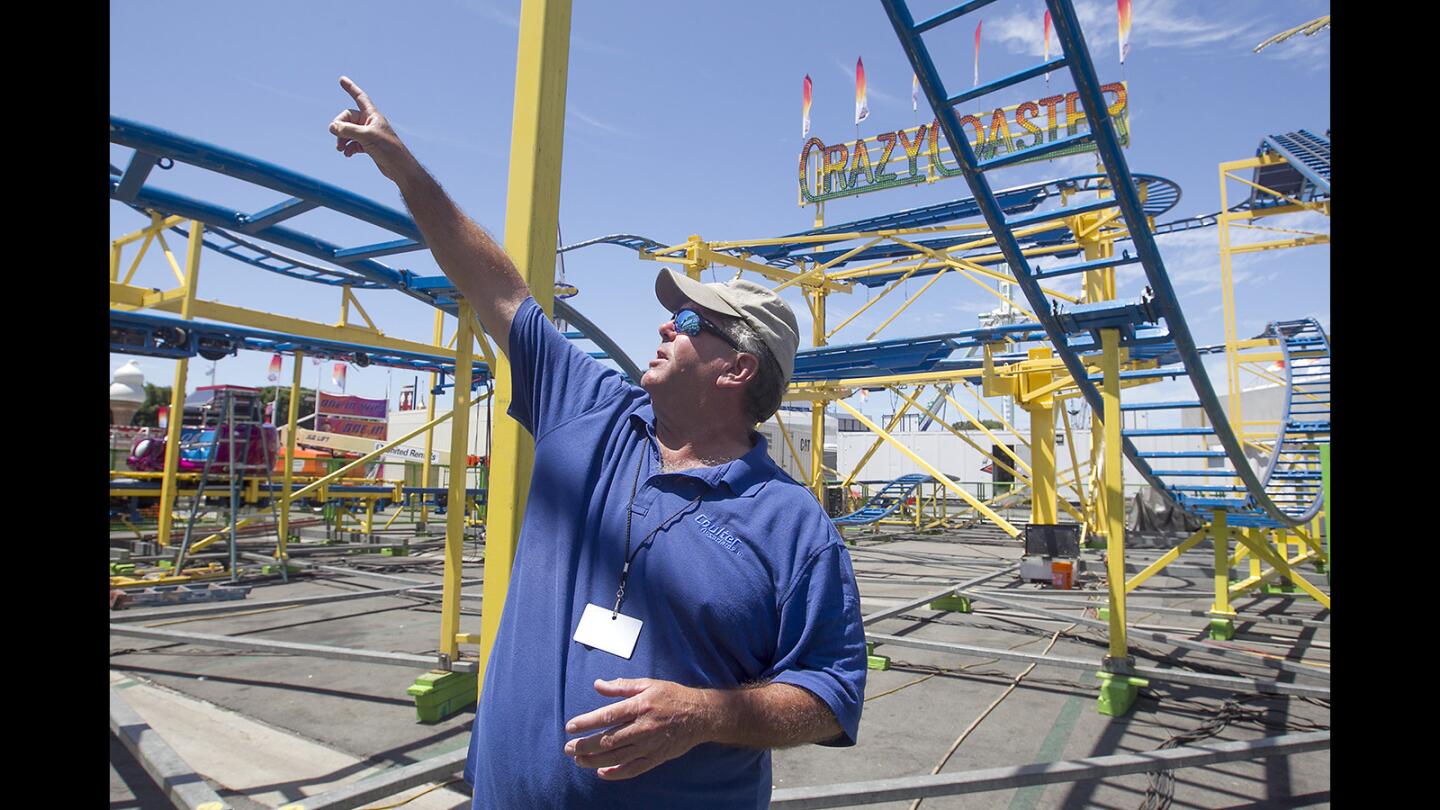 Ride inspector Al Scanlan talks about the tracks and air brakes on the Crazy Coaster on Thursday, the day before opening day of the Orange County Fair.