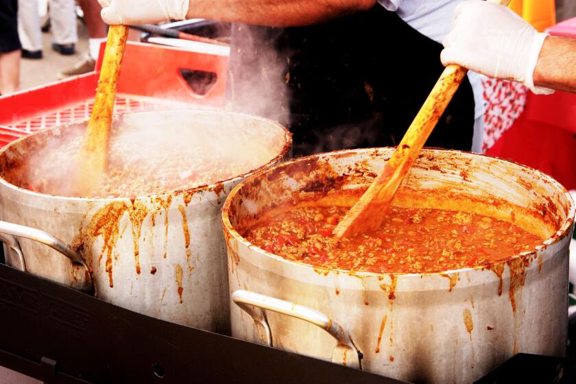chili being cooked in big pots