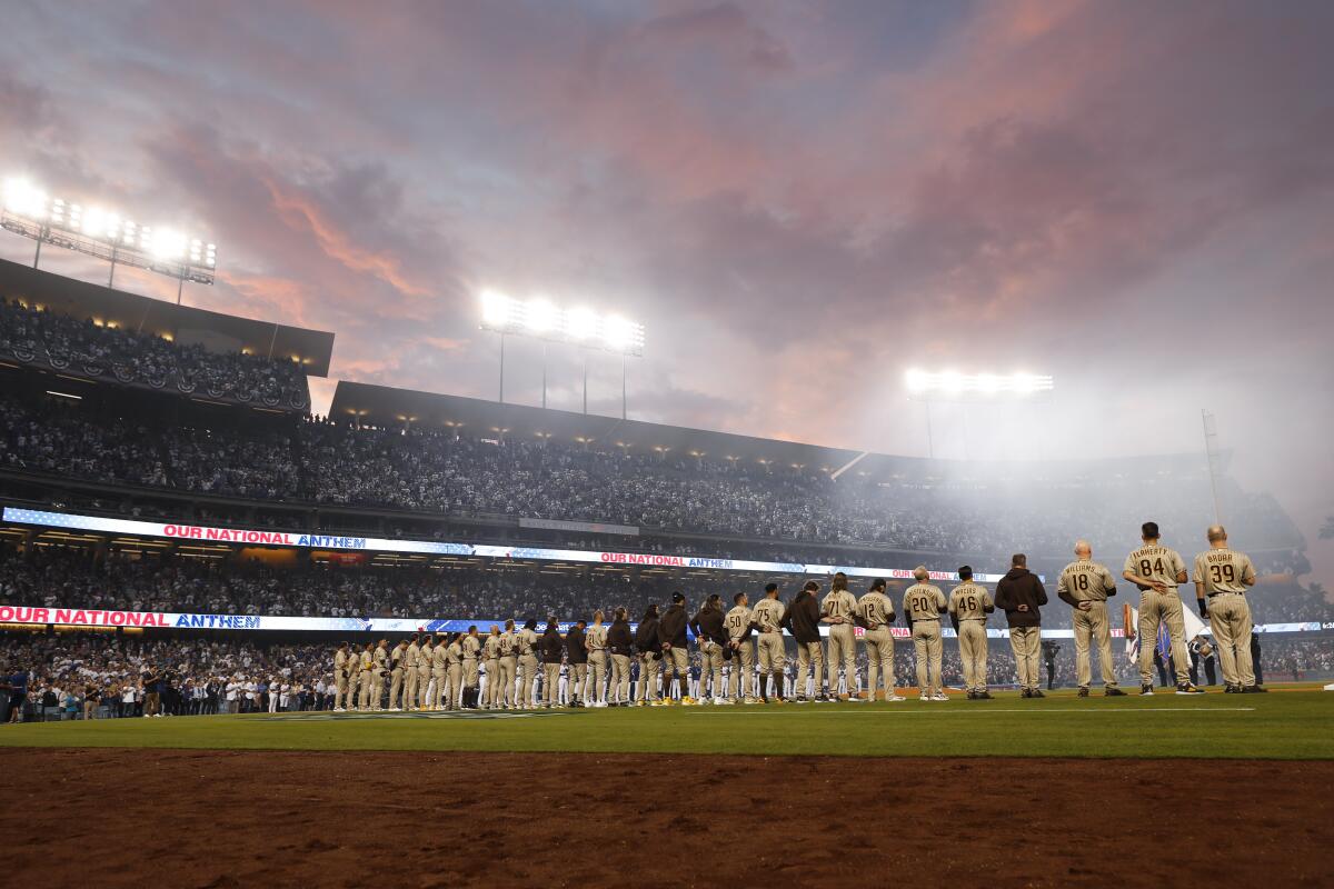 Baseball players line up on the field before a game.
