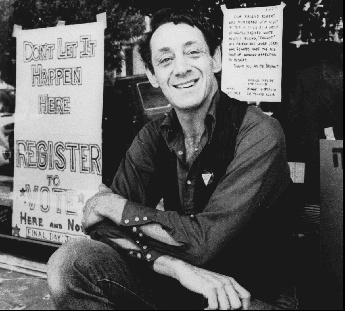 Harvey Milk poses in front of his camera shop in San Francisco in 1977.