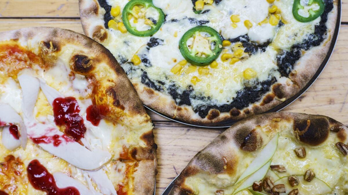 The imaginative pizzas from Los Cancinos, from left, featuring turkey and blueberry sauce, huitlacoche and Oaxaca cheese, and pears and gorgonzola.