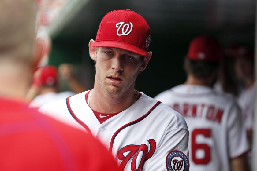 Nationals starting pitcher Stephen Strasburg walks in the dugout before a game against the Marlins.