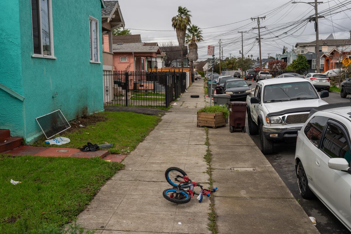Le vélo d'un enfant repose sur un trottoir.