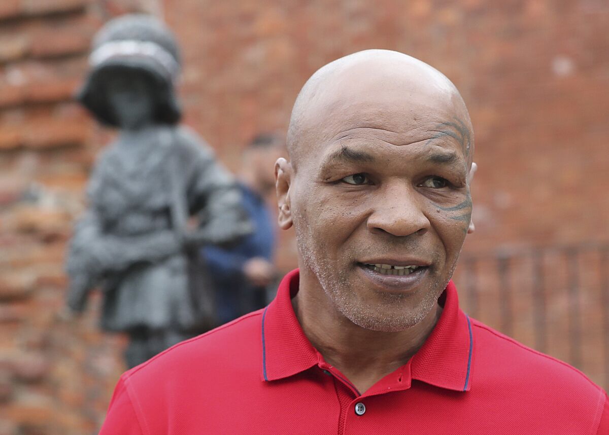 Mike Tyson, an American former heavyweight boxing champion, stands in front of a memorial to Polish suffering during World War II, during a visit to Warsaw, Poland, on Thursday June 27, 2019. (AP Photo/Czarek Sokolowski)