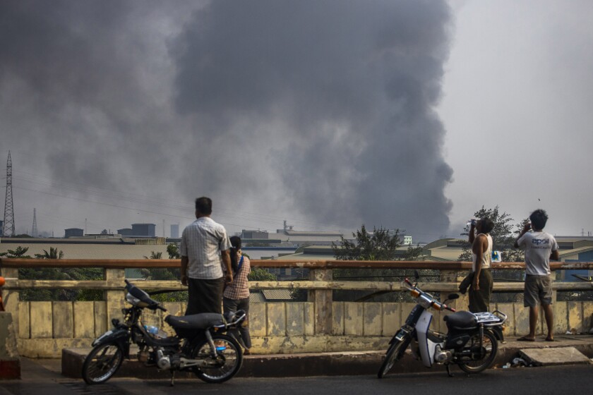 Black smoke billows from the industrial zone of Hlaing Thar Yar township in Yangon, Myanmar Sunday, March 14, 2021. Attacks on Chinese-run factories in Myanmar's biggest city drew demands Monday from Beijing for protection for their property and employees, while many in Myanmar expressed outrage over China's apparent lack of concern for those killed in protests against last month's military coup. Myanmar state media have reported that martial law was declared in six districts in Yangon, including the major industrial zones of Hlaing Thar Yar and Shwepyitha. (AP Photo)