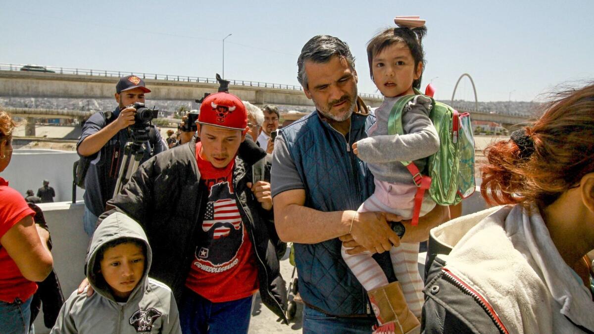 Central American migrants cross into the United States at the El Chaparral border crossing, in Tijuana on May 4.