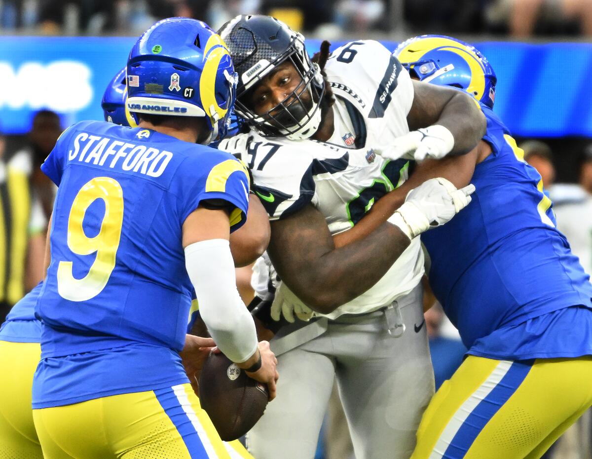 Rams quarterback Matthew Stafford eyes pressure from Seahawks defensive end Mario Edwards Jr. 
