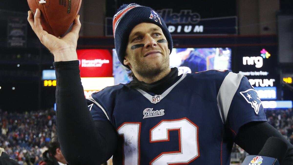 New England Patriots quarterback Tom Brady holds up a game ball after his team's 35-31 AFC divisional playoff win over the Baltimore Ravens on Saturday.