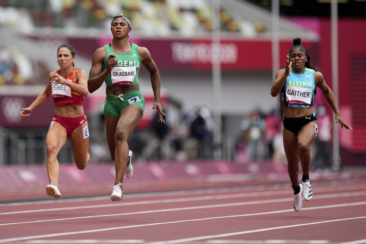 FILE - In this July 30, 2021 file photo, Blessing Okagbare, of Nigeria, center, wins a heat in the women's 100-meter run at the 2020 Summer Olympics, in Tokyo. Nigerian sprinter Okagbare is facing three charges in a doping case which surfaced in dramatic circumstances when she was barred from running in the Olympic 100-meter semifinals hours before the race. The Athletics Integrity Unit revealed on Thursday, Oct. 7, 2021, that Okagbare tested positive for blood booster EPO in Nigeria in June, in addition to another failed test for human growth hormone in Slovakia in July, which was announced during the Olympics. (AP Photo/Petr David Josek, file)