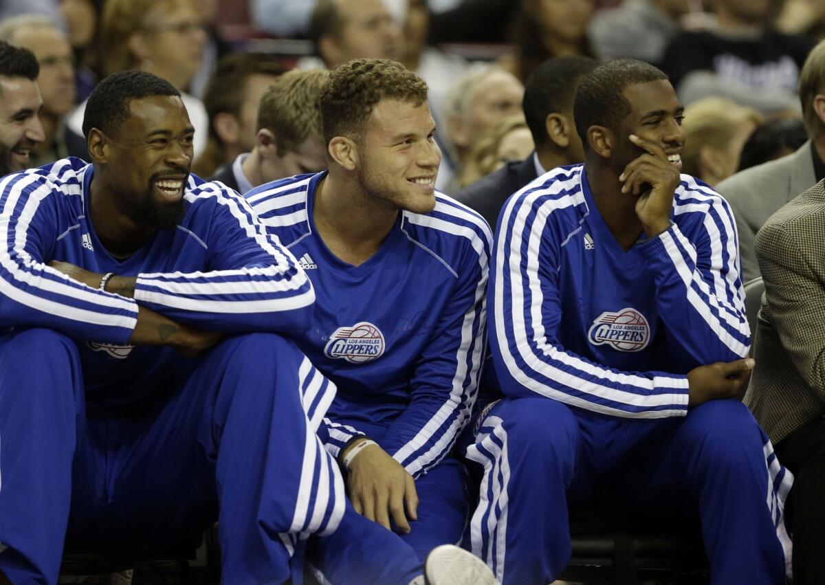 DeAndre Jordan, left, Blake Griffin and Chris Paul watch from the bench as the Clippers play the Sacramento Kings in an exhibition game Monday.